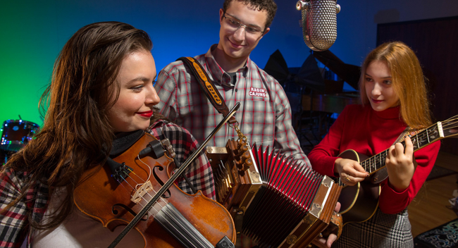 Three University of Louisiana at Lafayette traditional music students playing in a campus music studio