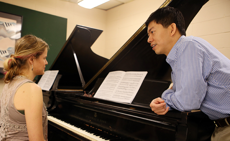 Professor works with student at piano