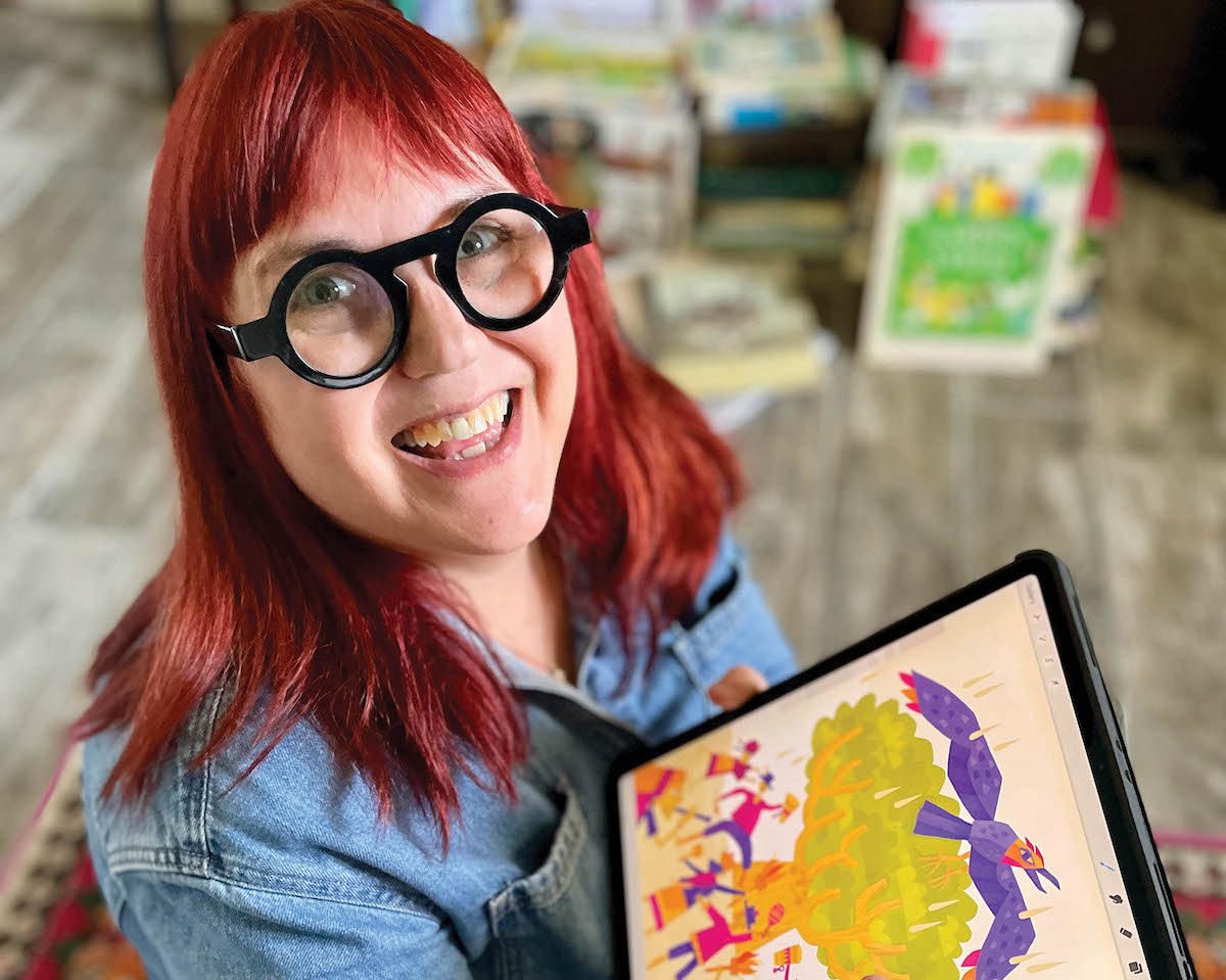 Artist Denise Gallagher holds up an illustration from her recent book project.