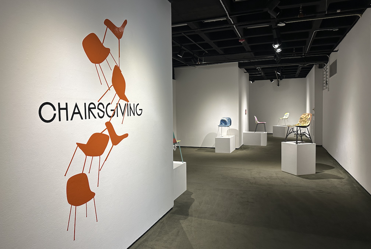 Entrance into the College of the Arts Fletcher Hall Gallery with Chairsgiving logo on the wall.