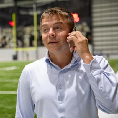 William Fralia, alumnus of UL Lafayette's sport management program, smiles as he speaks on his cell phone with a client.