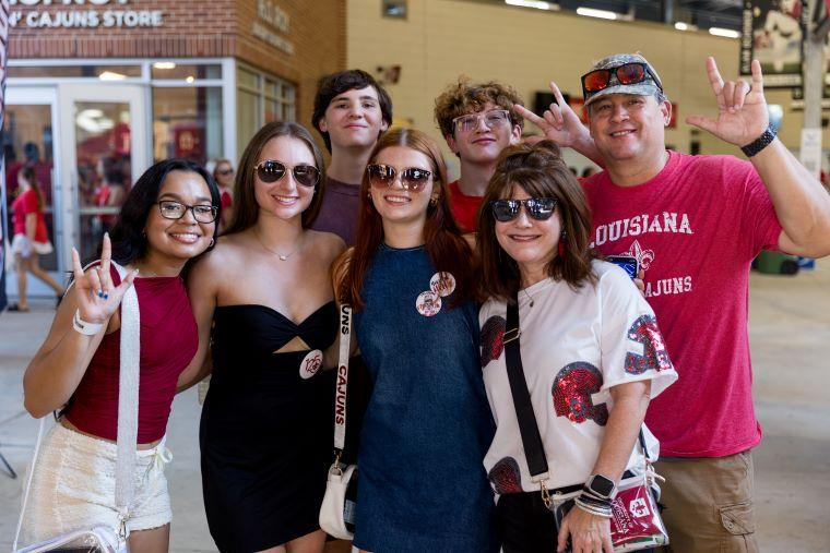A family wearing red and black gameday attire poses at Family Weekend